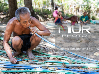 Sarjono (73), an elderly blind man, takes water from the only source of water by sucking it up and flowing it through a hose to his house du...