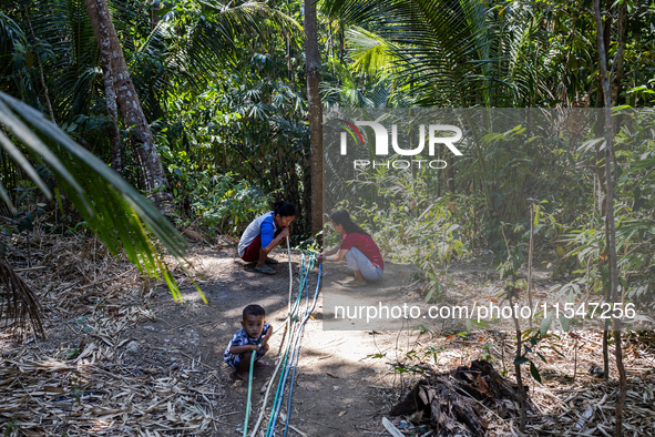 Residents hold a water hose before flowing it to their house during drought season in Selopamioro Village, Bantul Regency, Yogyakarta Provin...