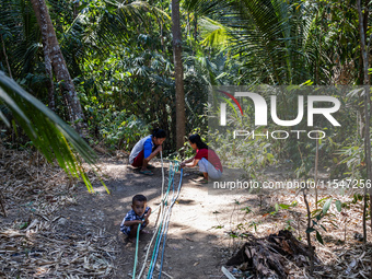 Residents hold a water hose before flowing it to their house during drought season in Selopamioro Village, Bantul Regency, Yogyakarta Provin...