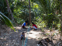 Residents hold a water hose before flowing it to their house during drought season in Selopamioro Village, Bantul Regency, Yogyakarta Provin...