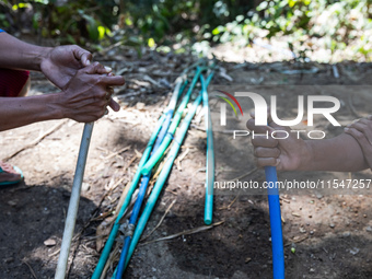 Residents hold a water hose before flowing it to their house during drought season in Selopamioro Village, Bantul Regency, Yogyakarta Provin...