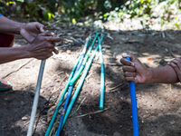 Residents hold a water hose before flowing it to their house during drought season in Selopamioro Village, Bantul Regency, Yogyakarta Provin...