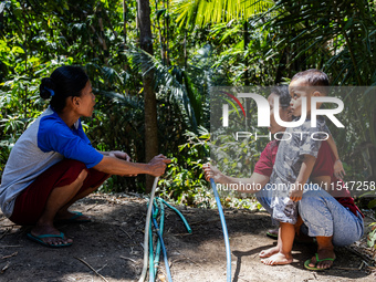 Residents hold a water hose before flowing it to their house during drought season in Selopamioro Village, Bantul Regency, Yogyakarta Provin...