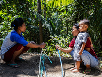 Residents hold a water hose before flowing it to their house during drought season in Selopamioro Village, Bantul Regency, Yogyakarta Provin...