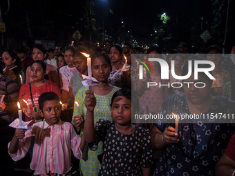 Citizens light candles in solidarity with the victim doctor who was raped and murdered at RG Kar Medical College and Hospital, during a prot...