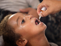 A Palestinian child receives a polio vaccination in the UK-MED field hospital in Khan Younis in the southern Gaza Strip, on September 5, 202...