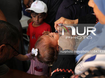 A Palestinian child receives a polio vaccination in the UK-MED field hospital in Khan Younis in the southern Gaza Strip, on September 5, 202...