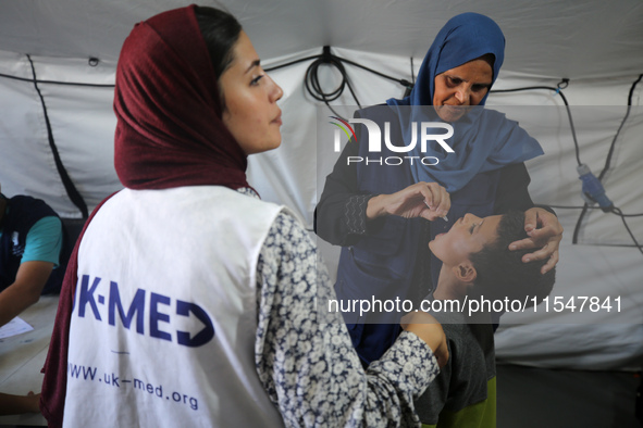 A Palestinian child receives a polio vaccination in the UK-MED field hospital in Khan Younis in the southern Gaza Strip, on September 5, 202...