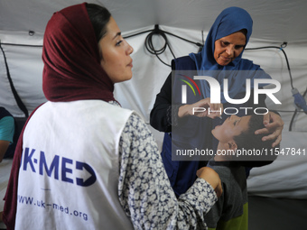 A Palestinian child receives a polio vaccination in the UK-MED field hospital in Khan Younis in the southern Gaza Strip, on September 5, 202...