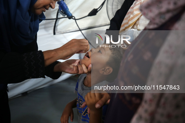 A Palestinian child receives a polio vaccination in the UK-MED field hospital in Khan Younis in the southern Gaza Strip, on September 5, 202...