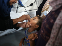 A Palestinian child receives a polio vaccination in the UK-MED field hospital in Khan Younis in the southern Gaza Strip, on September 5, 202...