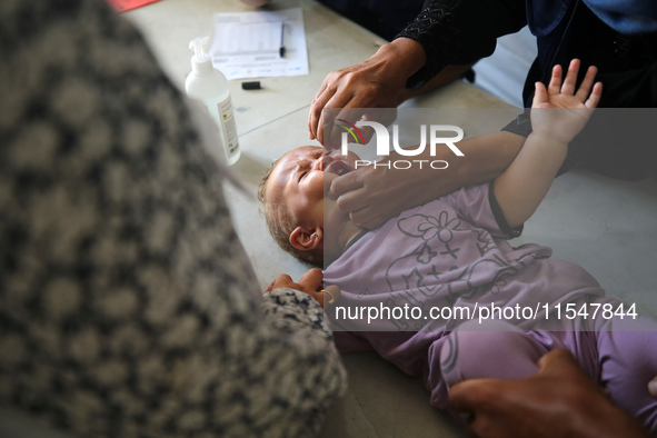 A Palestinian child receives a polio vaccination in the UK-MED field hospital in Khan Younis in the southern Gaza Strip, on September 5, 202...