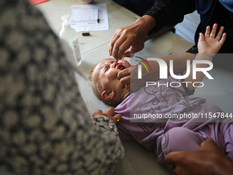 A Palestinian child receives a polio vaccination in the UK-MED field hospital in Khan Younis in the southern Gaza Strip, on September 5, 202...