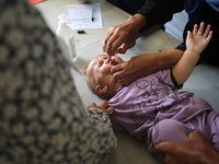 A Palestinian child receives a polio vaccination in the UK-MED field hospital in Khan Younis in the southern Gaza Strip, on September 5, 202...