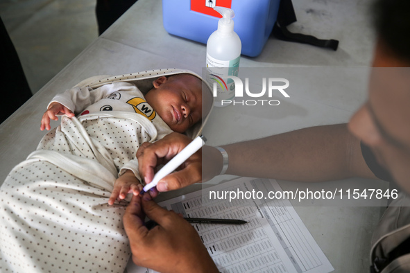 A Palestinian child receives a polio vaccination in the UK-MED field hospital in Khan Younis in the southern Gaza Strip, on September 5, 202...