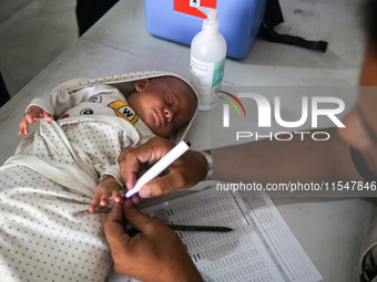 A Palestinian child receives a polio vaccination in the UK-MED field hospital in Khan Younis in the southern Gaza Strip, on September 5, 202...