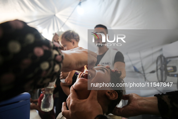 A Palestinian child receives a polio vaccination in the UK-MED field hospital in Khan Younis in the southern Gaza Strip, on September 5, 202...