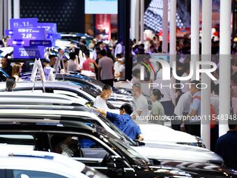 People look at various vehicles at the 23rd Autumn International Auto Show in Qingdao, China, on September 5, 2024. (