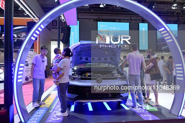 People look at various vehicles at the 23rd Autumn International Auto Show in Qingdao, China, on September 5, 2024. 