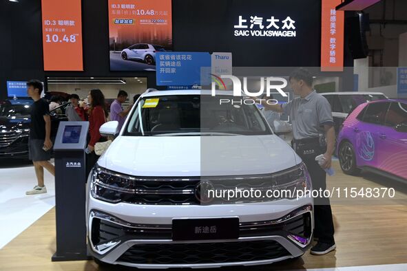 People look at various vehicles at the 23rd Autumn International Auto Show in Qingdao, China, on September 5, 2024. 