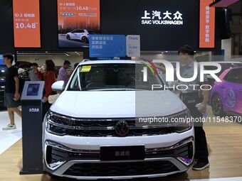 People look at various vehicles at the 23rd Autumn International Auto Show in Qingdao, China, on September 5, 2024. (