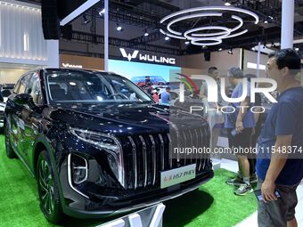 People look at various vehicles at the 23rd Autumn International Auto Show in Qingdao, China, on September 5, 2024. (