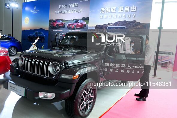 People look at various vehicles at the 23rd Autumn International Auto Show in Qingdao, China, on September 5, 2024. 