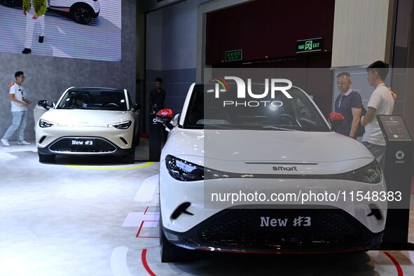 People look at various vehicles at the 23rd Autumn International Auto Show in Qingdao, China, on September 5, 2024. 