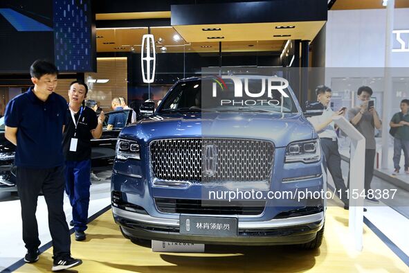 People look at various vehicles at the 23rd Autumn International Auto Show in Qingdao, China, on September 5, 2024. 