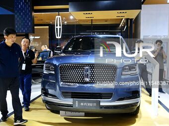 People look at various vehicles at the 23rd Autumn International Auto Show in Qingdao, China, on September 5, 2024. (