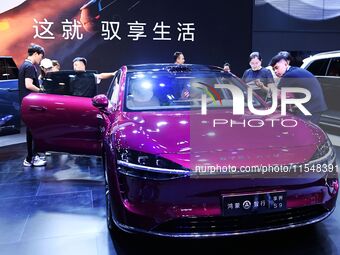 People look at various vehicles at the 23rd Autumn International Auto Show in Qingdao, China, on September 5, 2024. (