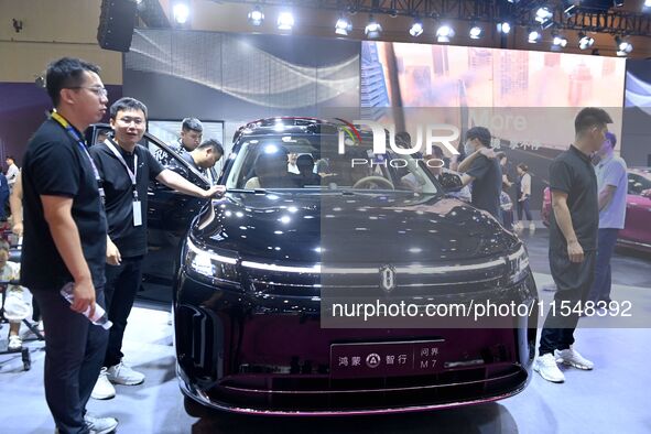 People look at various vehicles at the 23rd Autumn International Auto Show in Qingdao, China, on September 5, 2024. 