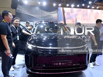 People look at various vehicles at the 23rd Autumn International Auto Show in Qingdao, China, on September 5, 2024. (