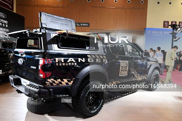 People look at various vehicles at the 23rd Autumn International Auto Show in Qingdao, China, on September 5, 2024. 