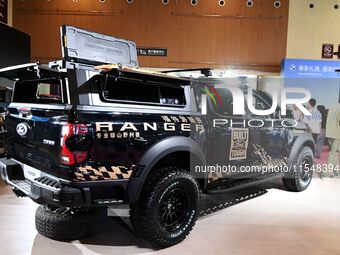 People look at various vehicles at the 23rd Autumn International Auto Show in Qingdao, China, on September 5, 2024. (