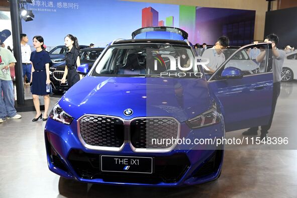 People look at various vehicles at the 23rd Autumn International Auto Show in Qingdao, China, on September 5, 2024. 