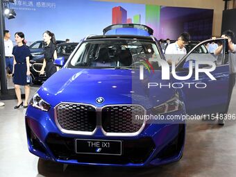 People look at various vehicles at the 23rd Autumn International Auto Show in Qingdao, China, on September 5, 2024. (