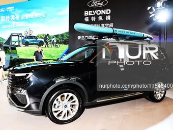 People look at various vehicles at the 23rd Autumn International Auto Show in Qingdao, China, on September 5, 2024. (