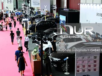 People look at various vehicles at the 23rd Autumn International Auto Show in Qingdao, China, on September 5, 2024. (