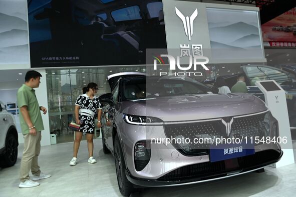 People look at various vehicles at the 23rd Autumn International Auto Show in Qingdao, China, on September 5, 2024. 