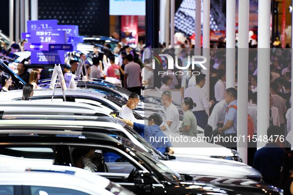 People look at various vehicles at the 23rd Autumn International Auto Show in Qingdao, China, on September 5, 2024. 