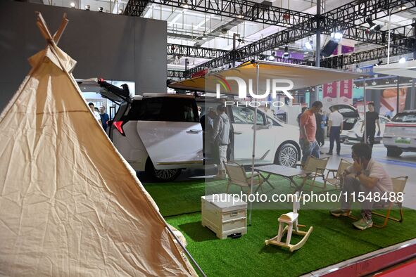 People look at various vehicles at the 23rd Autumn International Auto Show in Qingdao, China, on September 5, 2024. 