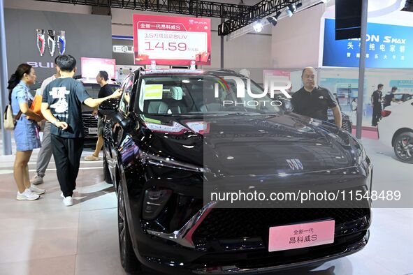 People look at various vehicles at the 23rd Autumn International Auto Show in Qingdao, China, on September 5, 2024. 