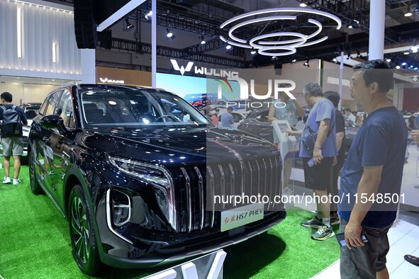 People look at various vehicles at the 23rd Autumn International Auto Show in Qingdao, China, on September 5, 2024. 