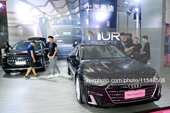 People look at various vehicles at the 23rd Autumn International Auto Show in Qingdao, China, on September 5, 2024. 