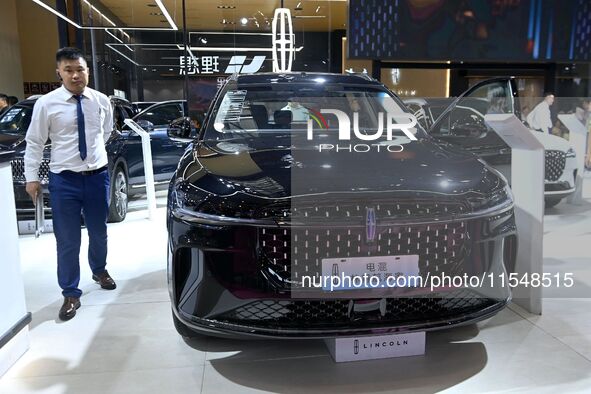 People look at various vehicles at the 23rd Autumn International Auto Show in Qingdao, China, on September 5, 2024. 