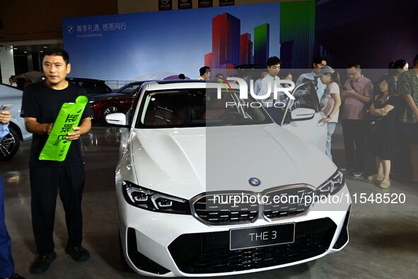 People look at various vehicles at the 23rd Autumn International Auto Show in Qingdao, China, on September 5, 2024. 