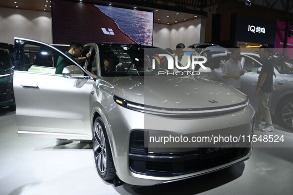 People look at various vehicles at the 23rd Autumn International Auto Show in Qingdao, China, on September 5, 2024. 