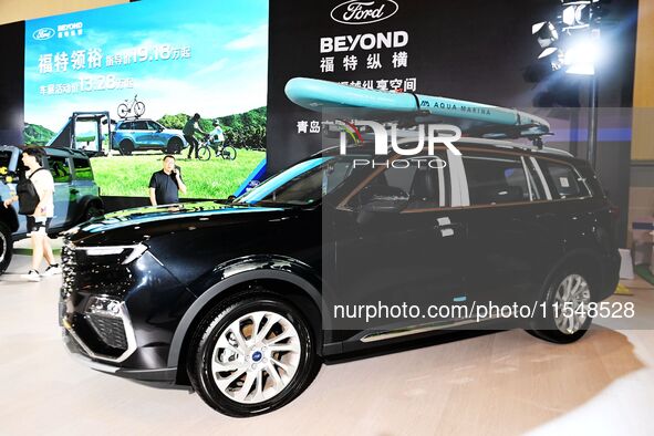 People look at various vehicles at the 23rd Autumn International Auto Show in Qingdao, China, on September 5, 2024. 