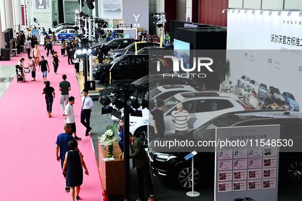 People look at various vehicles at the 23rd Autumn International Auto Show in Qingdao, China, on September 5, 2024. 